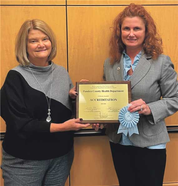 At Right, Melanie Dixon, director, receives the accreditation award from Teresa Ellen, NC Accreditation Board Chair.